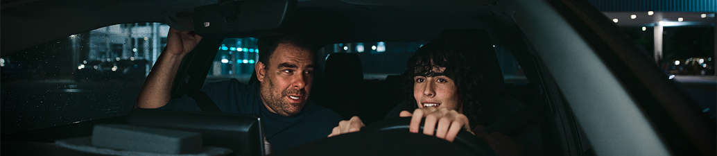 Man teaching teenage son how to drive.