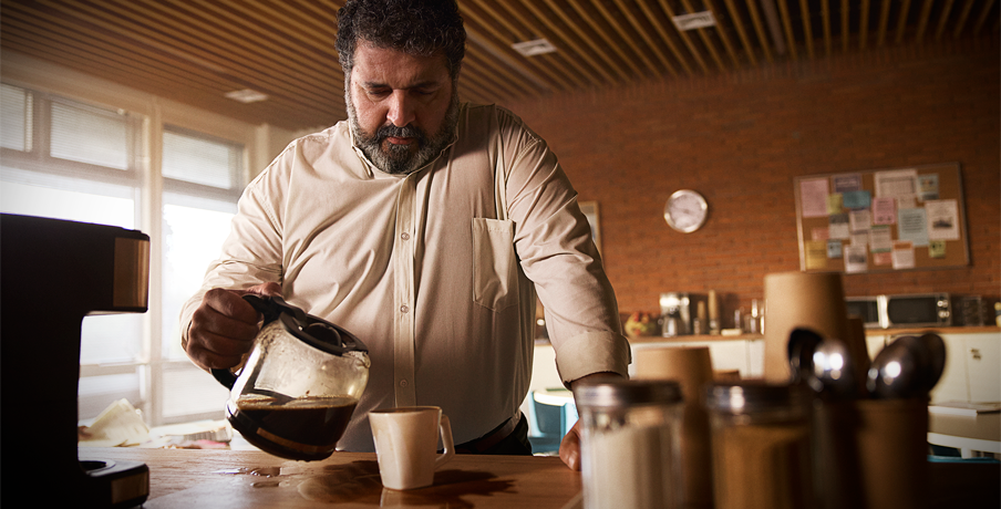 Man pouring coffee into an overflowing cup