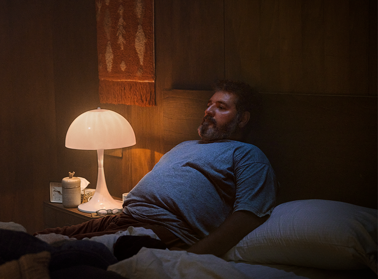 Man sitting upright in bed.